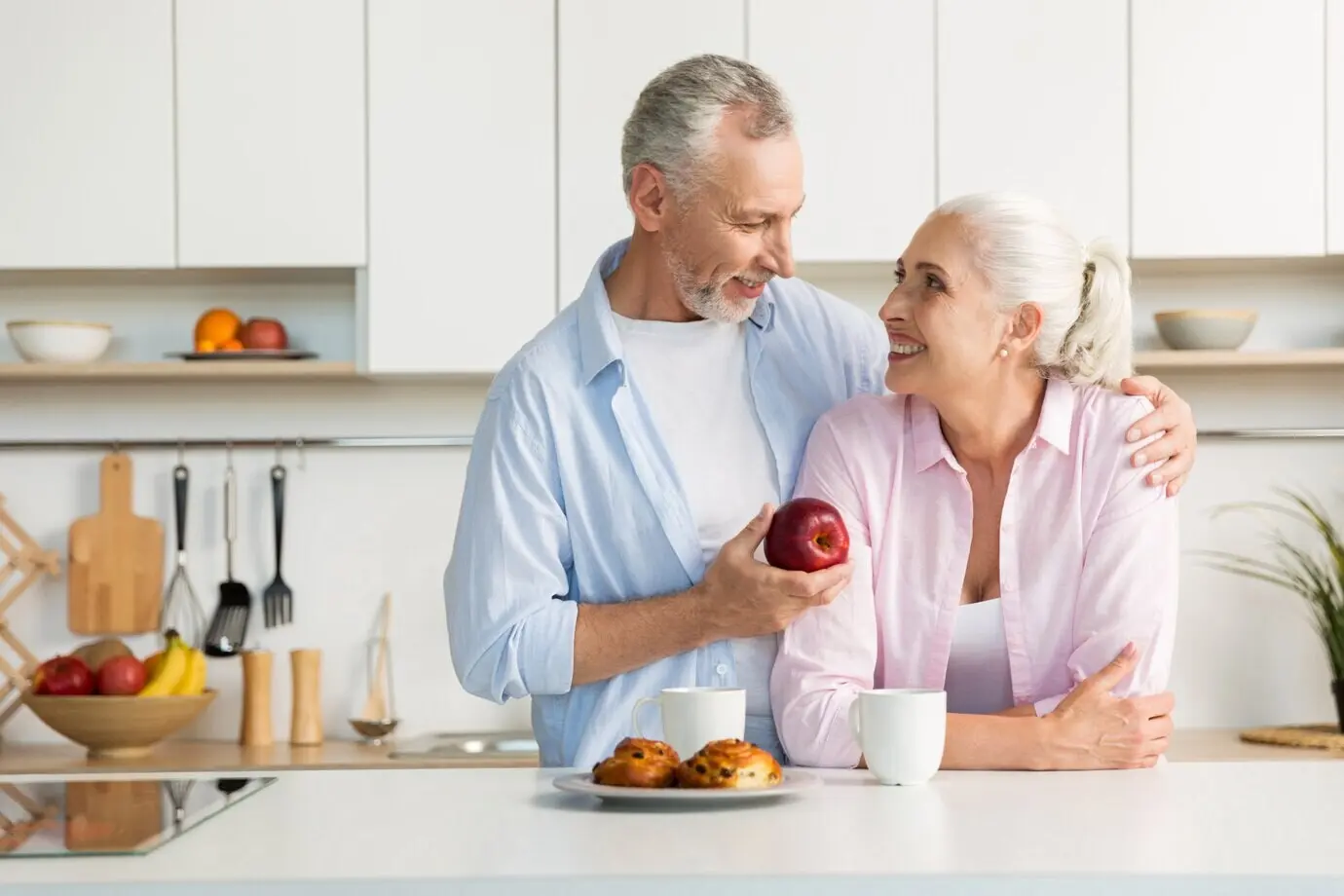 A smiling, loving, mature family couple standing in the kitchen
